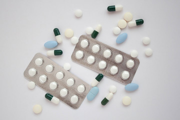 White and blue pills on white background close up