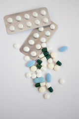 White and blue pills on white background close up