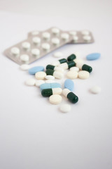 White and blue pills on white background close up