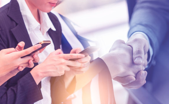 Business deal in Communication Industry with handhsake and Smartphone user for Business global communication concept