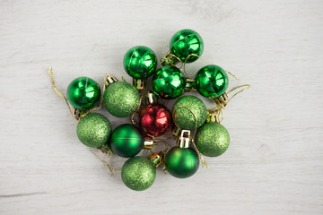 Winter holidays background with christmas decorations, christmas geen,red balls- toys. On a white wooden background. Selective focus, top view - bright colorful holiday atmosphere.