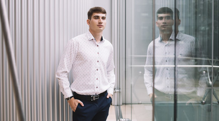 Confident businessman in front of reflection in window