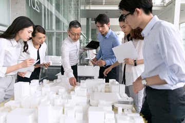 建築模型を使って打ち合せをするビジネス男女