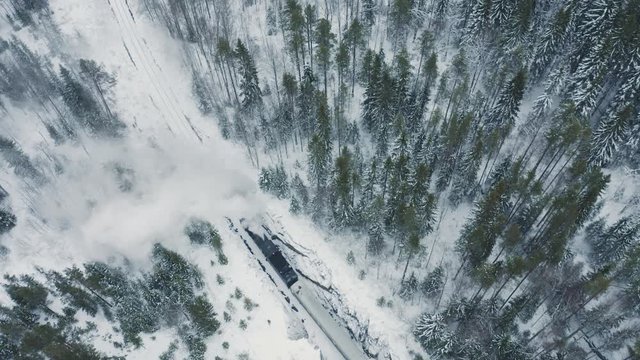 Aerial view retro steam train in snow covered forest