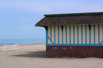 Yellow and blue beach hut on empty beach