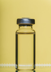 Glass medical ampoule vial for injection. Medicine is liquid sodium chloride with of aqueous solution in ampulla. Close up. Bottles ampule multicolor on background color and water. Human plasma.