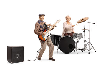 Elderly woman playing drums and man playing an electric guitar