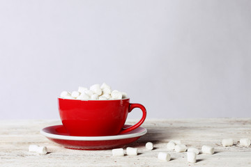 Big red Cup with coffee and marshmallows on white background.. Copy space. The concept of still life.