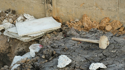 big iron hammer on ground near foundation piles cavity