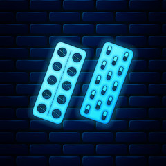 Glowing neon Pills or capsules in blister package icon isolated on brick wall background. Tablets in package. Medications Accessory pharmacies and first aid kits. Vector Illustration