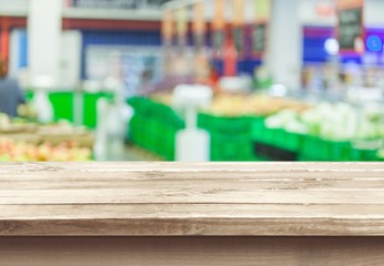 Brown desk in a white empty room lit by the sun
