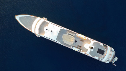 Aerial drone top down photo of luxury yacht docked in Aegean deep blue sea at sunset with beautiful golden colours, Greece