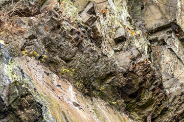Massive Felswand aus Schiefergestein mit Felsvorsprüngen, grünem Moos, schroffen Kanten und steilen Klippen zeigt ein Kletterparadies für Free Climbing, Kletterer und Wanderer durch felsiges Gebirge