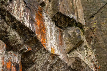 Massive Felswand aus Schiefergestein mit Felsvorsprüngen, grünem Moos, schroffen Kanten und steilen Klippen zeigt ein Kletterparadies für Free Climbing, Kletterer und Wanderer durch felsiges Gebirge