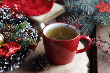 The cup is red. Christmas mood. Greeting card. The concept of needlework, winter pastime, comfort, home warmth.