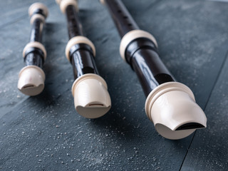 baroque flutes or recorders on wooden background, musical education concept, music school