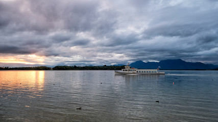 Dawn on Chiemsee Lake. In the foreground is a pleasure boat. Bavaria, Germany