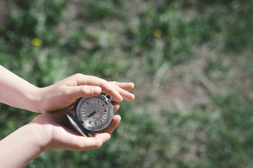 Girl's hands holding silver pocket clock, close-up