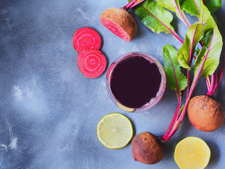 Obraz na płótnie Canvas Fresh beetroot, lime slice and juice top view on grey background with copy space on the left side of the picture for healthy food concept.