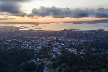 Fototapeta na wymiar A serene sunset illuminates the densely populated San Francisco Bay area including Oakland, Berkeley, Emeryville, El Cerrito, and San Francisco in the distance.