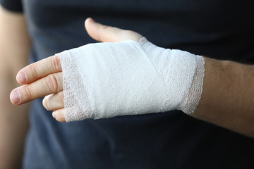 Obraz premium Male hand with tight elastic bandage on arm closeup