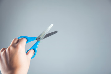 woman hand holding blue scissors