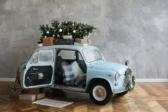 Christmas decorated classic car. A vintage car decorated for New year holidays loaded with festive gifts. Christmas retro car decorated loaded with Christmas tree and presents