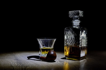 bottle of whiskey with glass and smoking pipe
