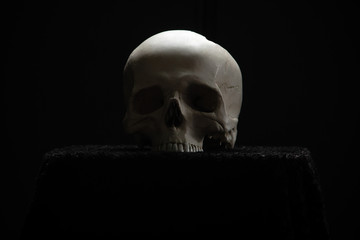 Skull lying on the altar in the dark on a black background.