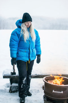 Woman standing with axe at winter