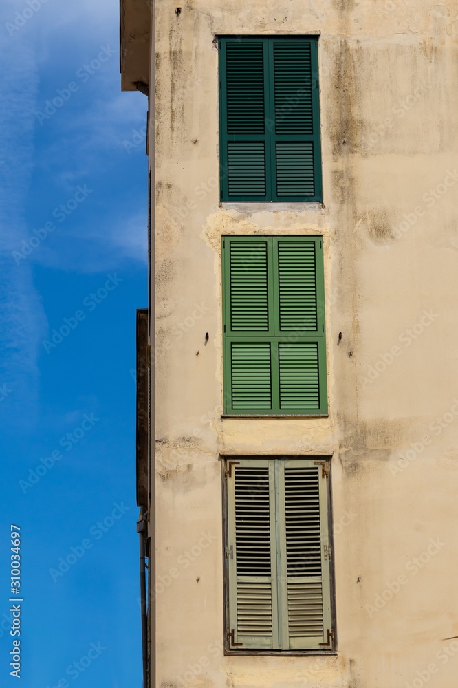 Poster vertical shot of an old concrete building with weathered windows with interesting textures