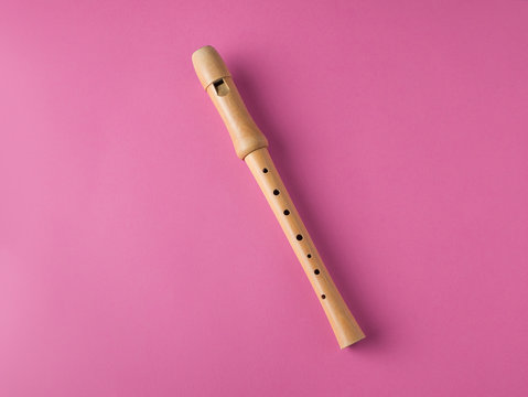 wooden recorder isolated on pink background