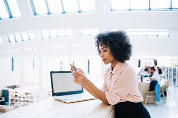 Serious afro american woman reading incoming email from financial director with information about...