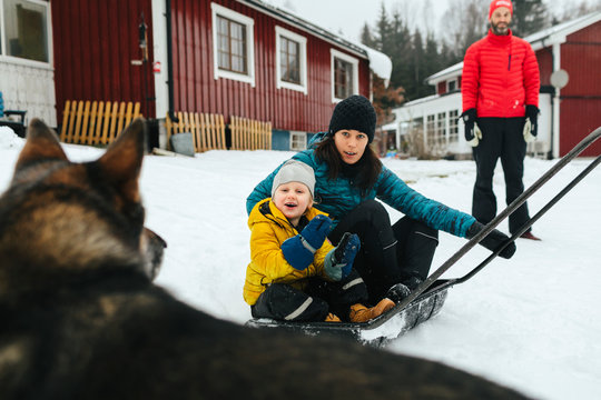 Mother with son on sleigh snow shovel