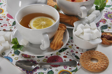 various cookies and biscuits baked at home in a container and tea in a retro cup with free space for text