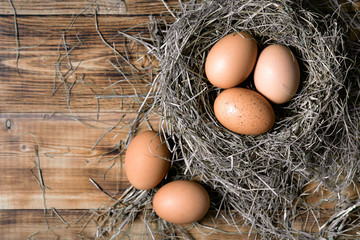Chicken eggs in wicker nests in chicken coop top view. Natural organic eggs in the hay. Fresh chicken eggs.