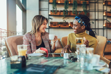 Two female friends talking at a coffee shop