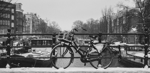 Fototapeta na wymiar Bicycle in the snow on a bridge over the Prinsengracht canal on a snowy winter day in Amsterdam
