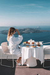 Young woman with blonde hair having breakfast in santorini greece
