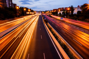 Fototapeta na wymiar Trails of car lights on a large road at night.