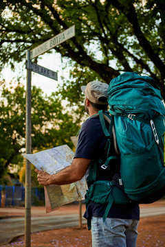 Backpacker checking the name of a street in his map