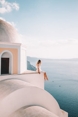 Young woman with white dress on rooftop in santorini greece