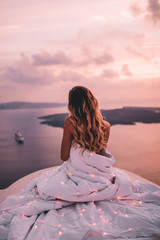 Young woman wrapped in sheets with blonde hair in santorini greece