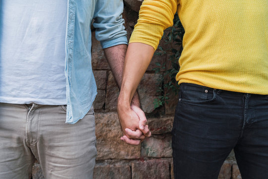 Crop view of gay couple hand in hand