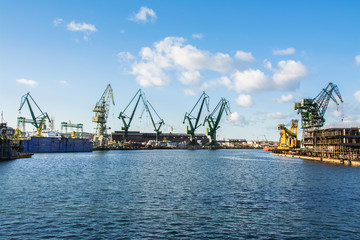 Fototapeta na wymiar View of the shipyard with historical cranes in the industrial part of the city Gdansk (Gdańsk) in Poland (Polska). The shipyard is close to the old town. Peaceful Motlawa river.