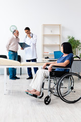 Old couple visiting young male doctor