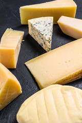 Different types of delicious cheese. Black background. Top view