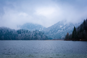 Berge und See mit Schnee und Wolken im Winter