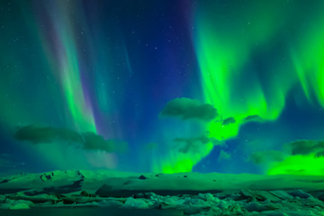 Aurora borealis in night northern sky. Ionization of air particles in the upper atmosphere.