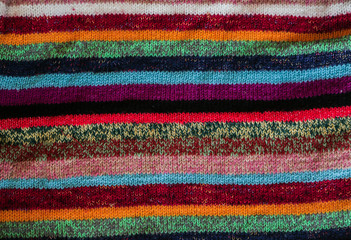 Colorful stripy woolen fabric texture close up. knitted background. Close up texture . wrinkled and shadows, top view